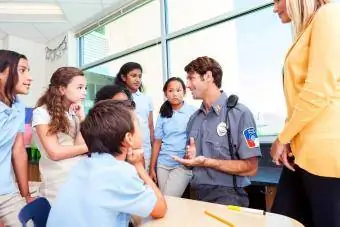 Kinderen die geïnteresseerd zijn in wat een politieagent te zeggen heeft over de veiligheid op hun school