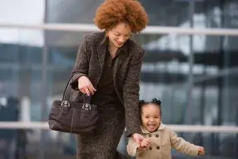 zaposlena mama drži hčerko za roko