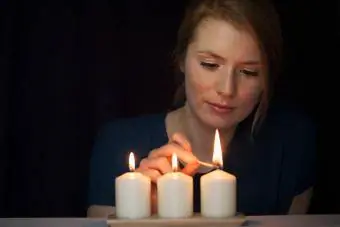 femeie care aprinde lumânări