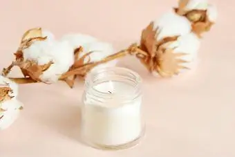 ბამბის ყვავილი და თეთრი სანთელი მინის ქილაში