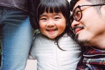 Miela maža mergaitė džiaugsmingai žiūri į kamerą