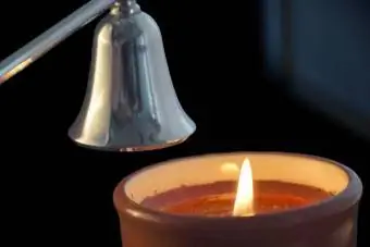 Vela prestes a ser apagada por um apagador de velas