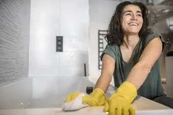 Mujer limpiando tina de fibra de vidrio