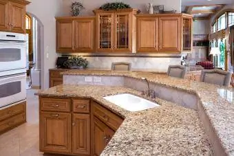 Prabangi virtuvė su granitiniais stalviršiais, ąžuolinėmis spintelėmis