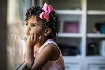 Portret djevojčice predškolske dobi koja gleda kroz prozor