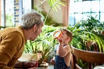 Nieto estudiando el rostro del abuelo con lupa