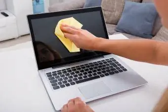Mão de mulher limpando tela de laptop