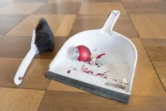 Čišćenje krhotina razbijene božićne kuglice na podu