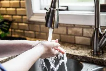 personne se lavant les mains dans la cuisine