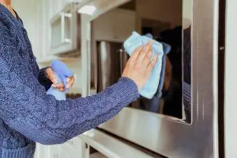mulher limpando vidro de forno