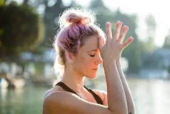 Femme méditant au bord d’un lac