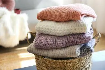 Pilha de blusas de malha de diferentes cores e padrões perfeitamente empilhadas