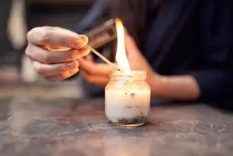 Dona amb una espelma encesa encesa en un pot de vidre