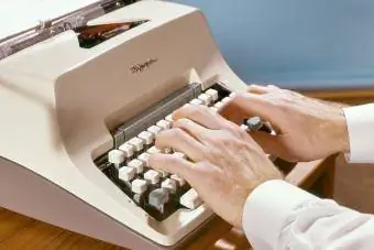 Bărbat care scrie la mașina de scris manuală Olympia