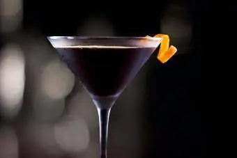 Coquetel escuro decorado com um toque de laranja em um bar escuro