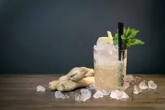 Cocktailglas og ingefær på bordet mod væggen