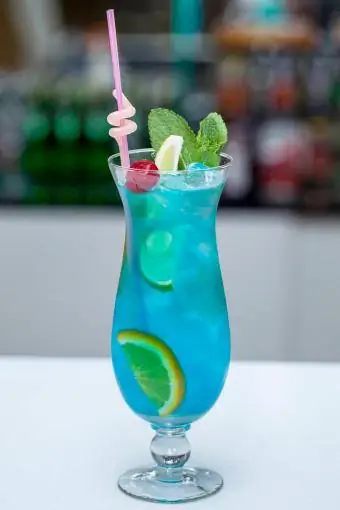 Blue Lagoon cocktail met een schijfje limoen en munt