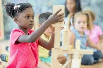 Meisje stapelt blokken op de kleuterschool