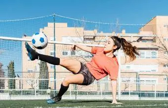 Gadis muda bermain sepak bola