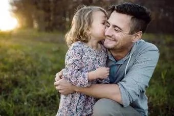 Lány csók apja arcán a mezőben