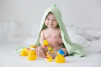 Lindo bebé niño pequeño jugando con patos de goma