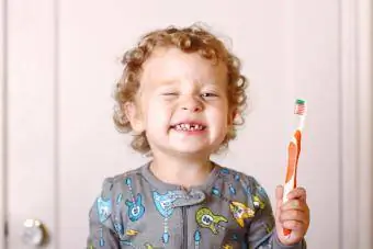 Pijamalı yürümeye başlayan çocuk dişlerini fırçalıyor