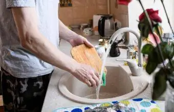 homme lavant une planche à découper