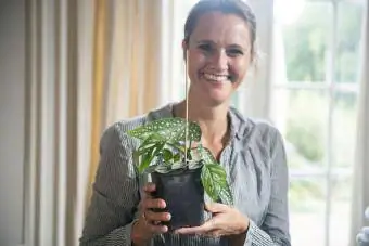 Femme posant avec des boutures fraîchement plantées