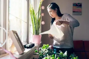 Femme arrosant les plantes chez elle