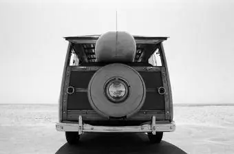 Old Woodie station wagon พร้อมกระดานโต้คลื่นที่ชายหาด