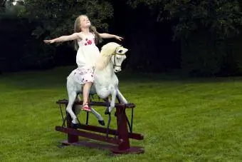 Vajza mbi një kalë lëkundëse