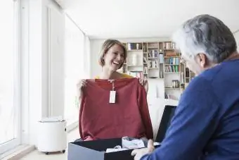 Femme tenant un pull pour que l'homme le voie