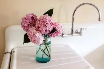 Arreglo de hortensias rosadas en el fregadero de la cocina