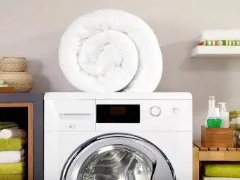 Melipat selimut pada mesin cuci di ruang cuci