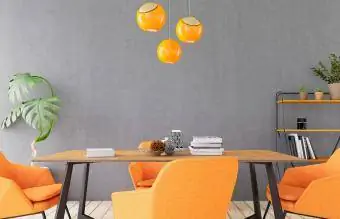 Бетонная стена со столом и оранжевым декором