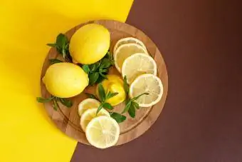 Bräda med skurna citroner och skal på träbord