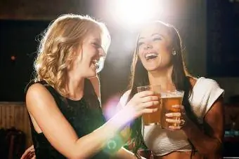 Kvinnor som njuter av hennes drinkar tillsammans på en nattklubb