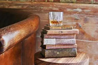 kubek whisky na zabytkowych książkach