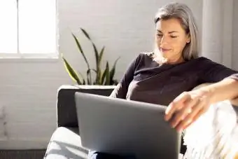 महिला लैपटॉप कंप्यूटर पर eBay खाता स्थापित कर रही है