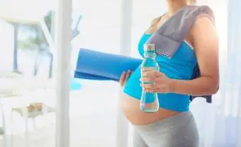 Mulher grávida se preparando para treinar em casa