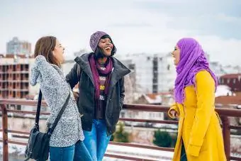 Çok etnik gruptan oluşan kadın arkadaş grubu kış yürüyüşü sırasında sohbet ediyor