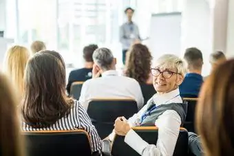 Gelukkig senior zakenvrouw op een seminar in een bestuurskamer