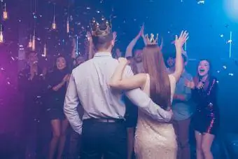 rei e rainha do baile enfrentando multidão de amigos torcendo