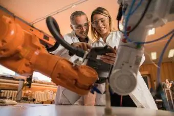 Robotičtí inženýři pracující na průmyslové robotické paži