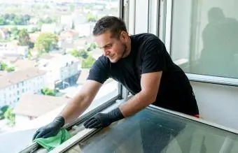 Mann som vasker vindusspor