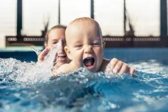 Een babyjongen van negen maanden tijdens zijn eerste zwemles