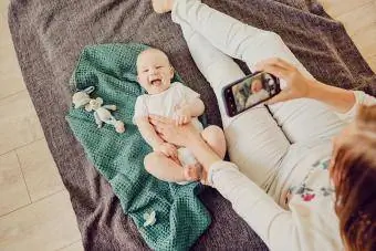 Mutter fotografiert ihr Baby mit dem Handy
