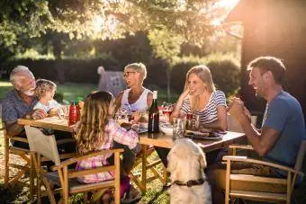 Glückliche Familie mit mehreren Generationen genießt das Abendessen in ihrem Hinterhof