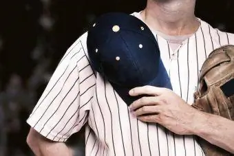 Jogador de beisebol segurando o chapéu sobre o coração para o hino nacional