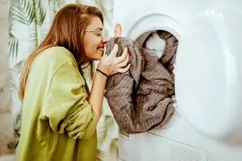 Genç kadın evde çamaşırlarını yıkıyor